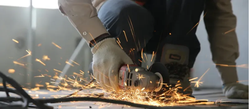 A sheet metal fabrication professional is cutting metal for industrial HVAC duct.