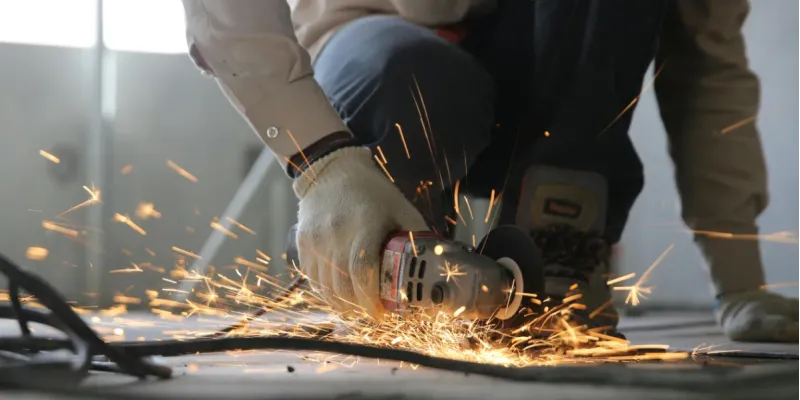 A worker is cutting sheet metal for fabrication.